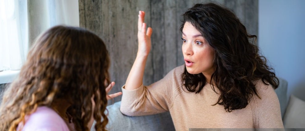 Woman argues with her teenage daughter while sitting at home